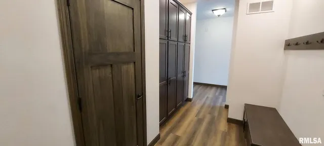 a view of a hallway with wooden floor and staircase