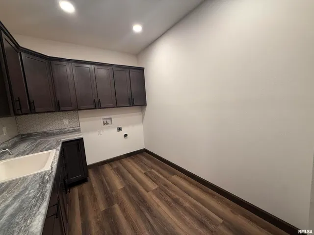 a kitchen with wooden floor and cabinets