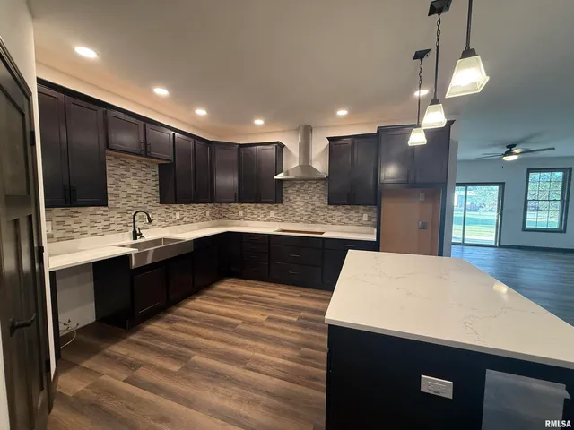 a large kitchen with kitchen island a sink stainless steel appliances and cabinets
