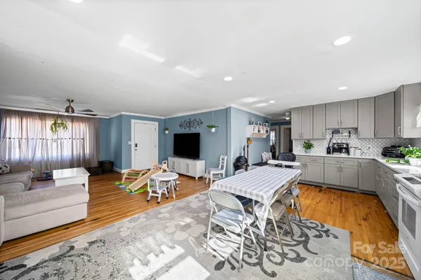 a large living room with stainless steel appliances kitchen island granite countertop a couch and a view of living room