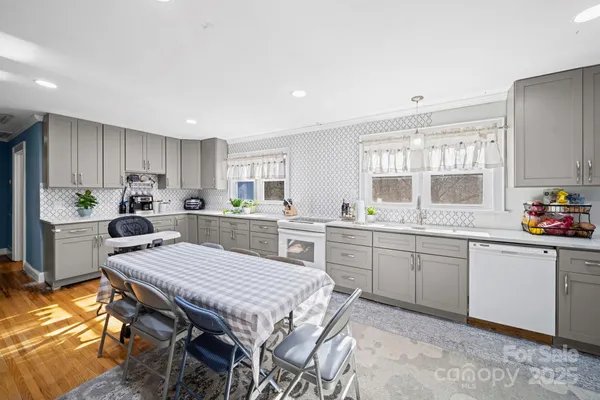 a kitchen with a table chairs sink and refrigerator