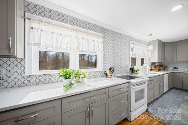 a white kitchen with sink and window
