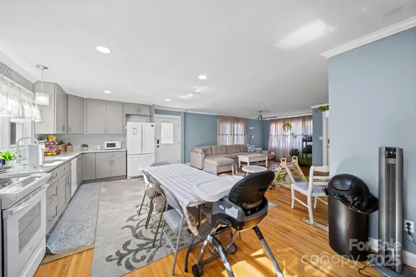 a view of a dining room with furniture a kitchen and chandelier