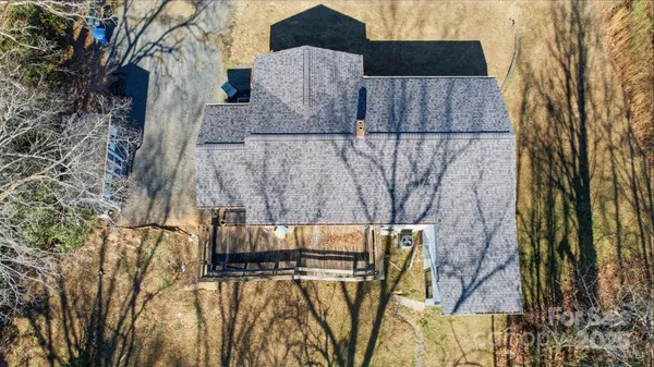 a view of backyard with wooden fence and large trees
