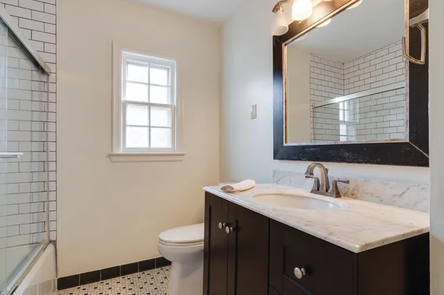 a bathroom with a sink toilet and mirror