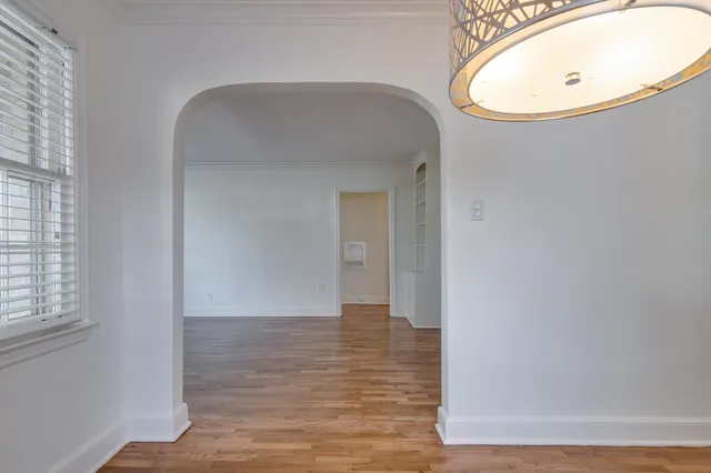 an empty room with wooden floor and mirror