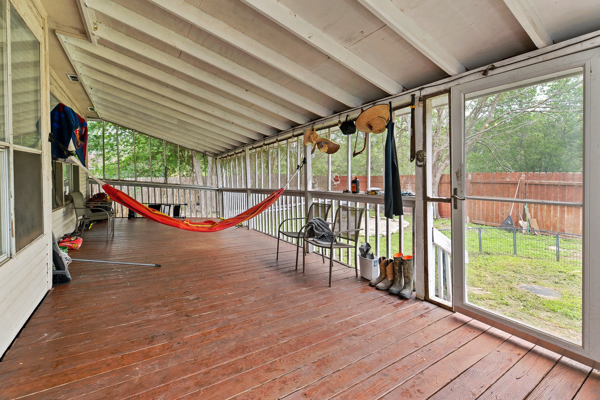 11737 Rydalwater Lane Austin, TX 78754 - Photo 36 of 40 Expansive screened porch with wood-finish flooring, a sloped ceiling, and a full-height screen door providing direct access to the backyard