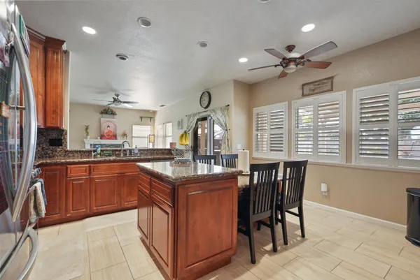 a kitchen with stainless steel appliances granite countertop a sink and a refrigerator