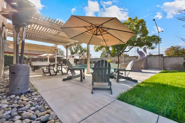 a view of a patio with a table and chairs under an umbrella