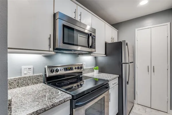 a kitchen with stainless steel appliances granite countertop a refrigerator stove and microwave