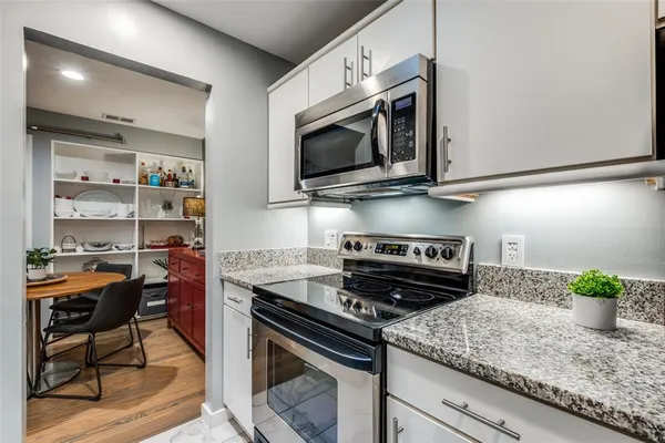 a kitchen with stainless steel appliances granite countertop a stove a microwave and cabinets