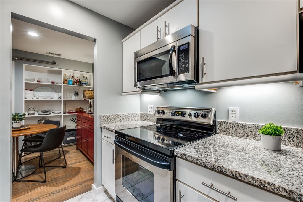 4231 Travis Street, Unit 17 Dallas, TX 75205 - Photo 18 of 26 a kitchen with stainless steel appliances granite countertop a stove a microwave and cabinets