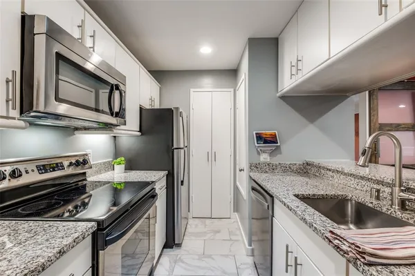 a kitchen with stainless steel appliances granite countertop a sink stove and refrigerator