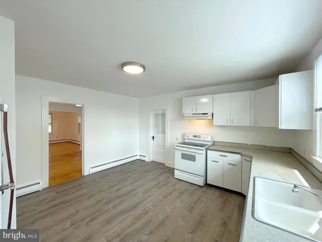 a kitchen with stainless steel appliances white cabinets and wooden floor