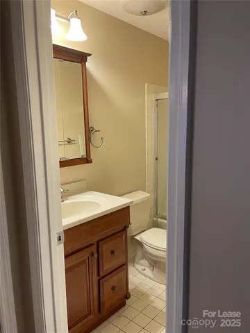 a bathroom with a granite countertop sink toilet and mirror