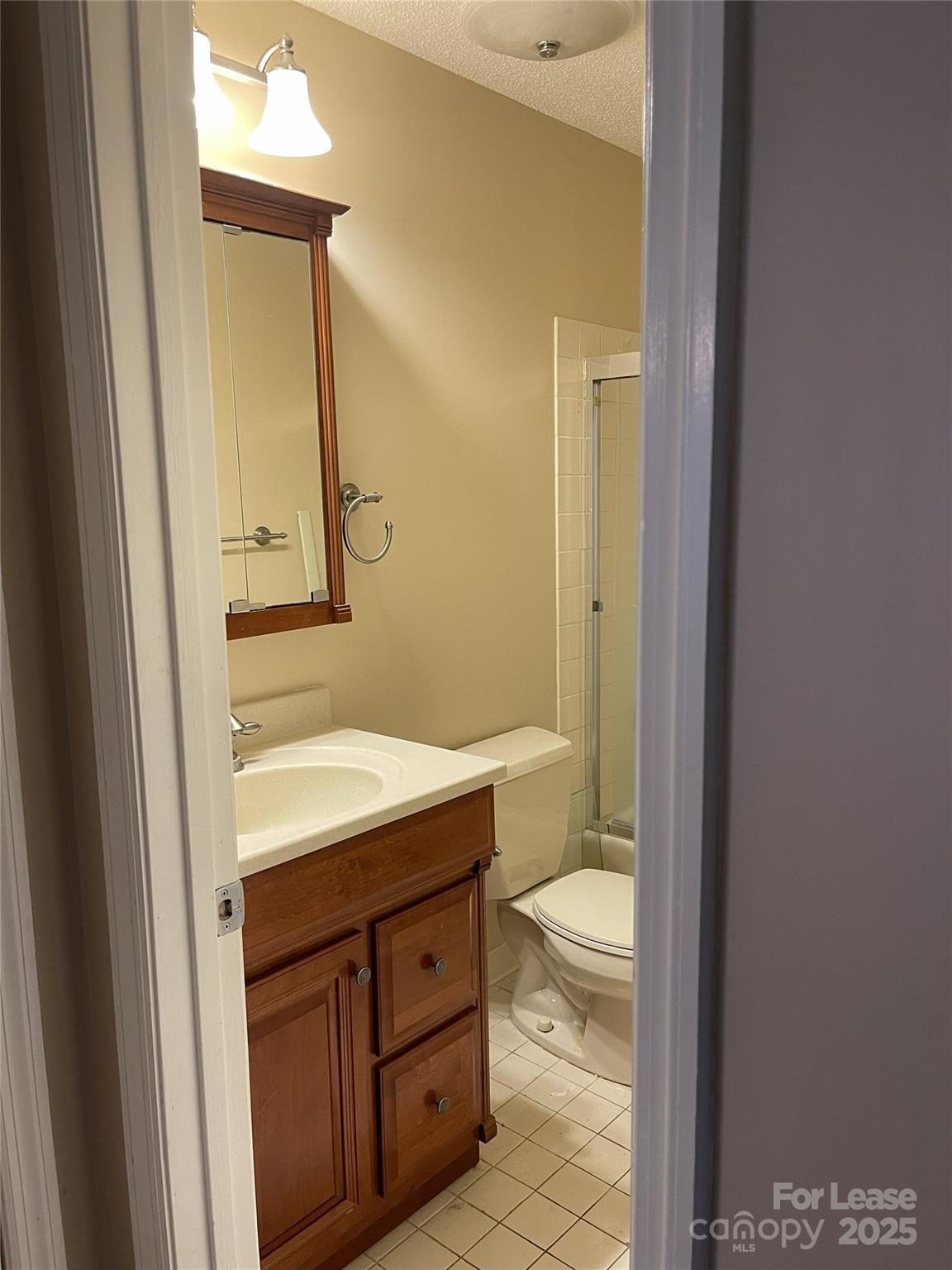 18701 Nautical Drive, Unit 203 Cornelius, NC 28031 - Photo 11 of 13 a bathroom with a granite countertop sink toilet and mirror