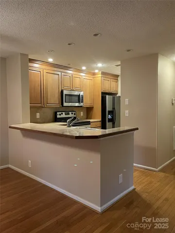 a kitchen with kitchen island a counter top space cabinets and stainless steel appliances