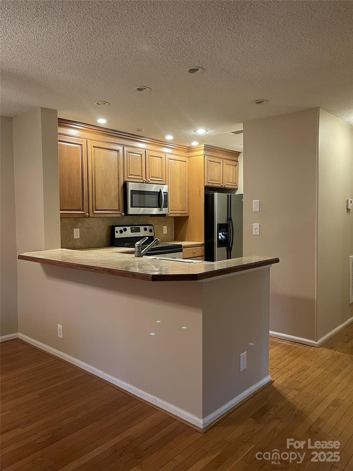 18701 Nautical Drive, Unit 203 Cornelius, NC 28031 - Photo 9 of 13 a kitchen with kitchen island a counter top space cabinets and stainless steel appliances