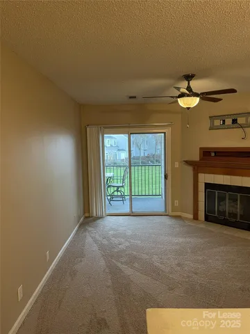 a view of an empty room with a fireplace and a window