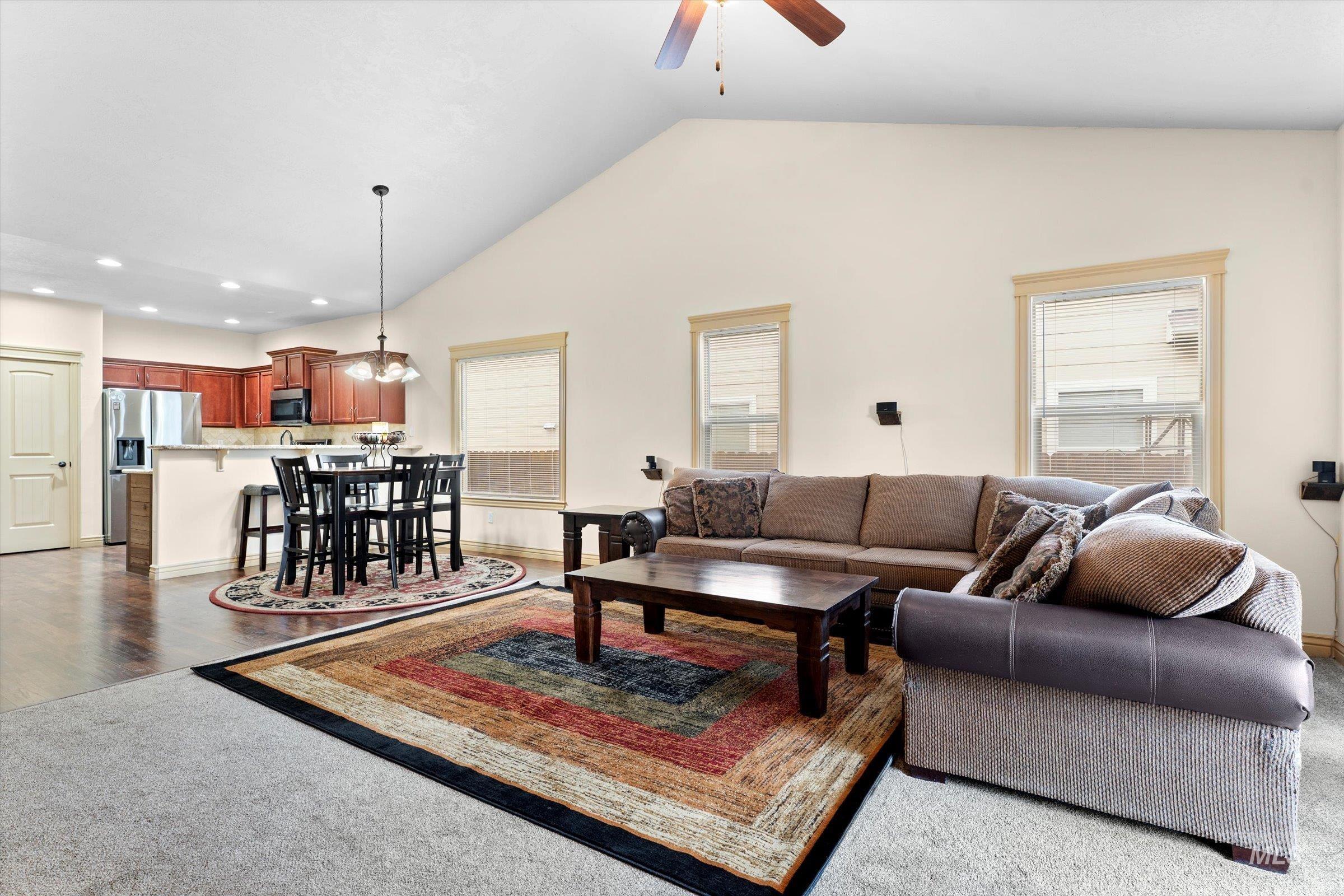 176 East Breinholt Street Meridian, ID 83646 - Photo 11 of 39 Living room featuring lofted ceiling, a ceiling fan, recessed lighting, and dark colored carpet
