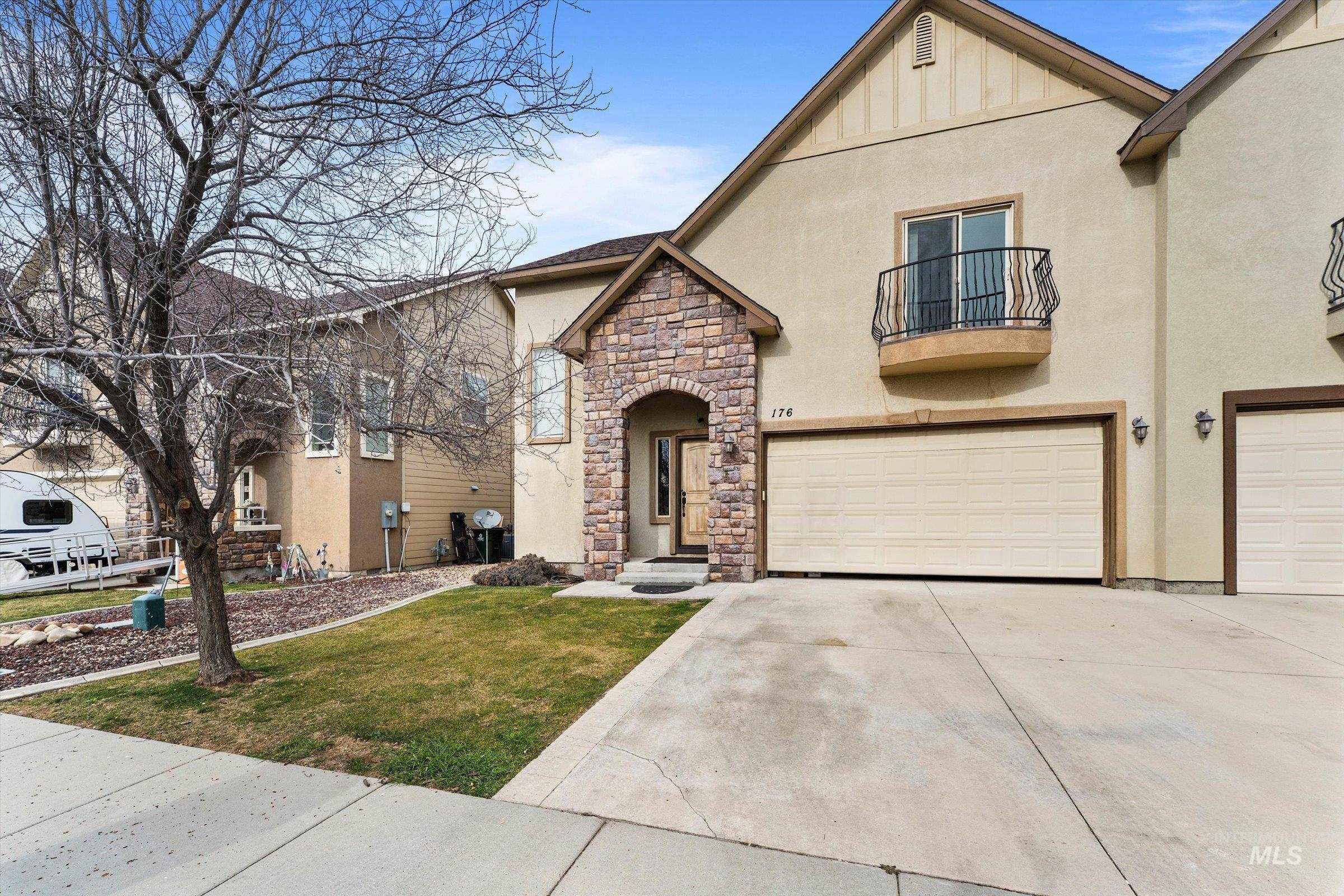 176 East Breinholt Street Meridian, ID 83646 - Photo 2 of 39 View of front of home with stucco siding, a balcony, concrete driveway, a front yard, and stone siding