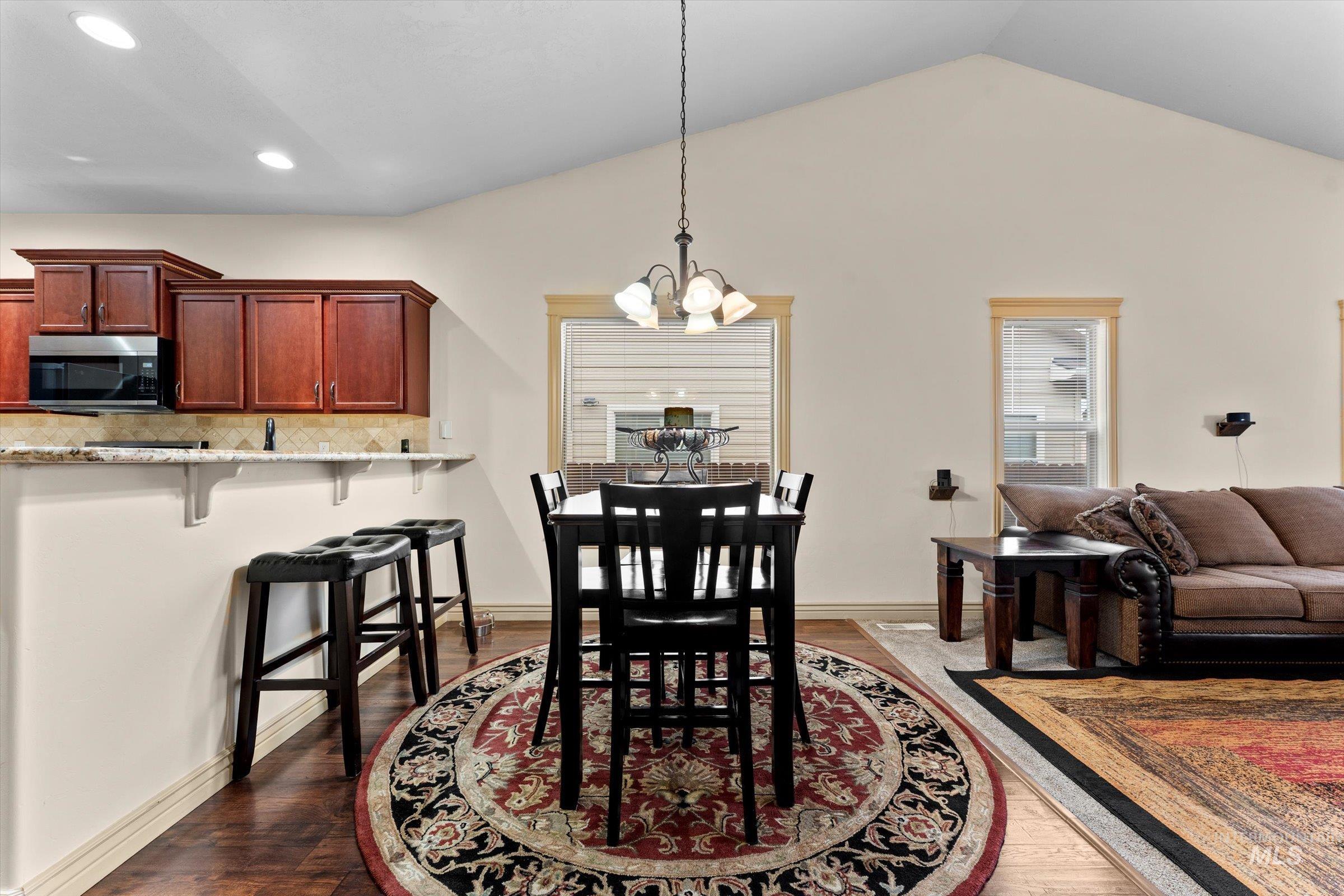 176 East Breinholt Street Meridian, ID 83646 - Photo 7 of 39 Dining room with a chandelier, dark wood-style floors, and lofted ceiling