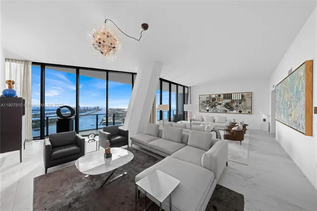 a living room with furniture and a painting on the wall