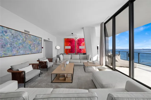 a living room with furniture and a floor to ceiling window