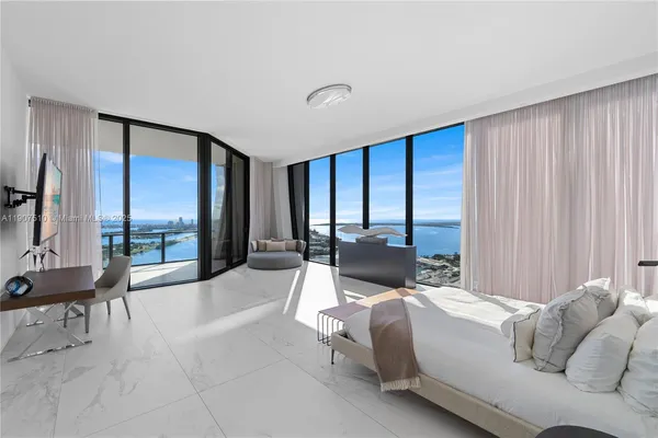 a spacious bedroom with a bed and a couch next to a window