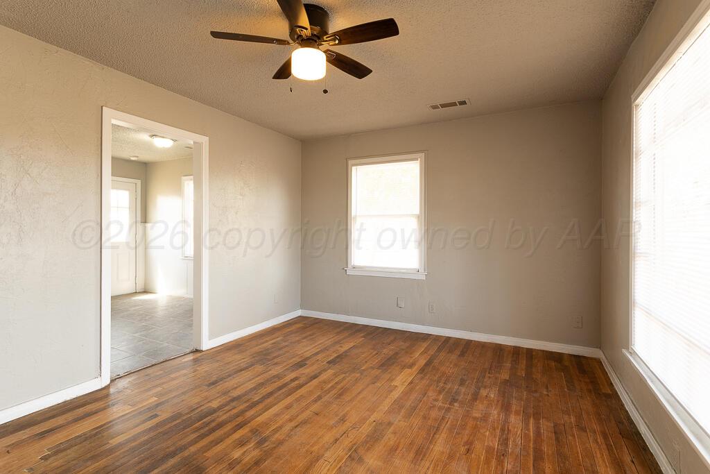 600 South Nelson Street Amarillo, TX 79104 - Photo 2 of 14 an empty room with wooden floor fan and windows