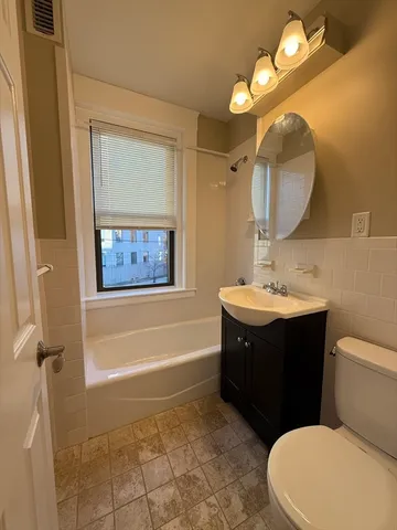 a bathroom with a sink vanity mirror and toilet