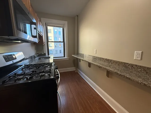 a kitchen with a stove a window and a refrigerator