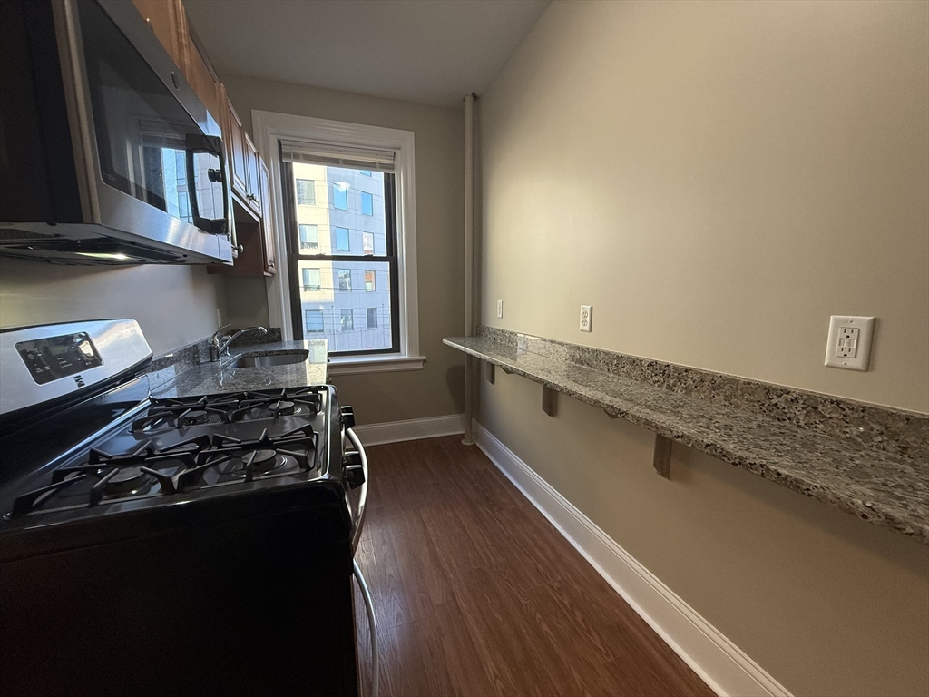 660 Huntington Avenue, Unit 23 Boston, MA 02115 - Photo 8 of 23 a kitchen with a stove a window and a refrigerator