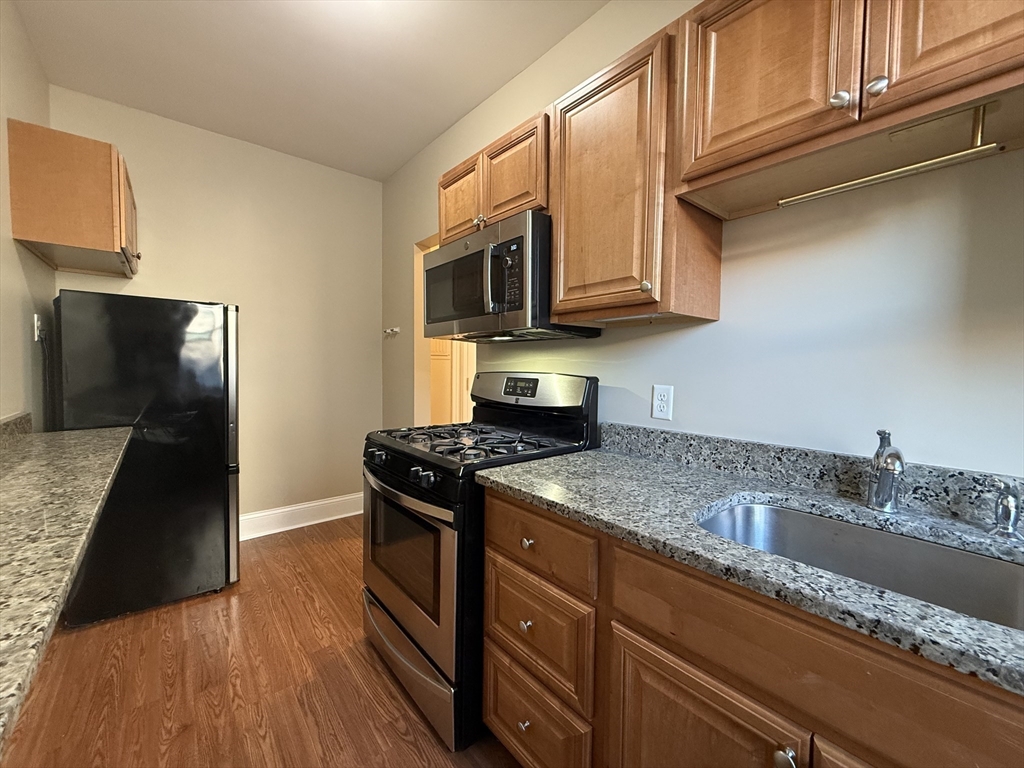 660 Huntington Avenue, Unit 23 Boston, MA 02115 - Photo 9 of 23 a kitchen with stainless steel appliances granite countertop a stove a sink and a microwave