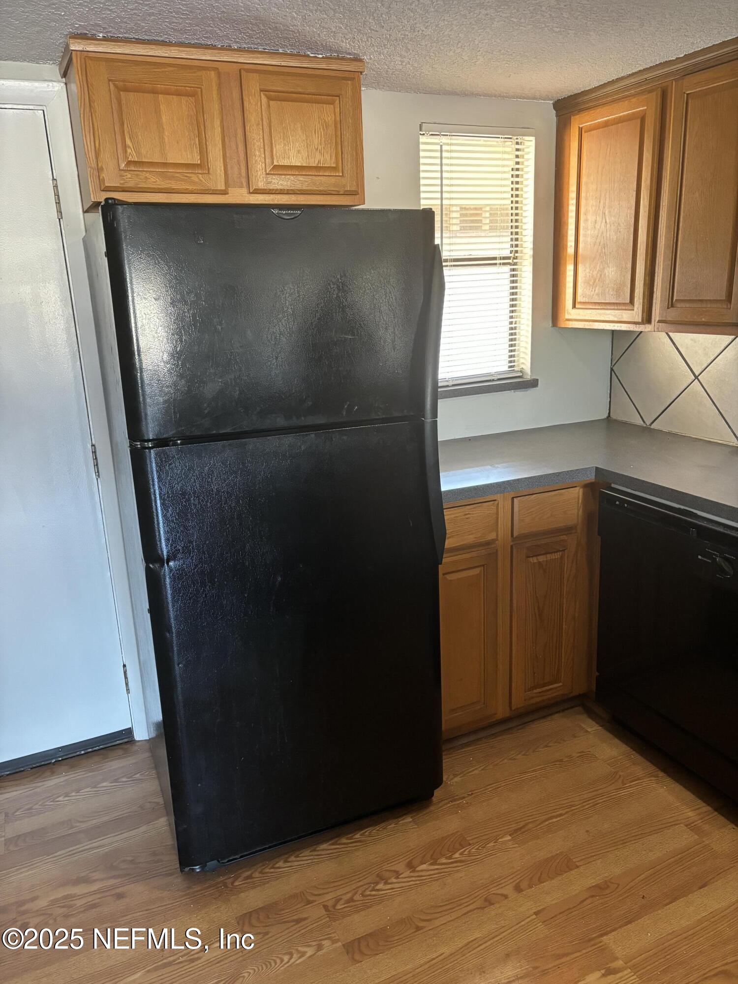 1000 3rd Street, Unit D Neptune Beach, FL 32266 - Photo 16 of 46 a kitchen with metallic cabinets and a refrigerator