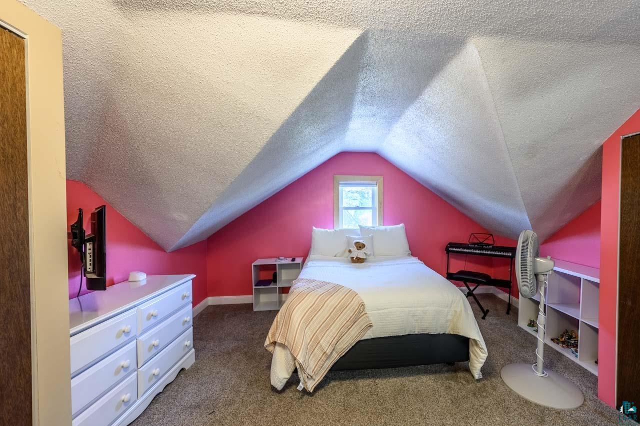 2581 O'Rourke Road Hibbing, MN 55746 - Photo 21 of 61 Room featuring sloped ceilings, a single window, and carpet flooring