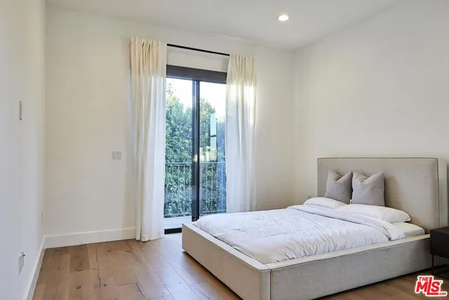 a bedroom with a bed and a large window