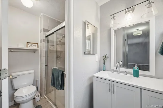 a bathroom with a granite countertop sink toilet and shower