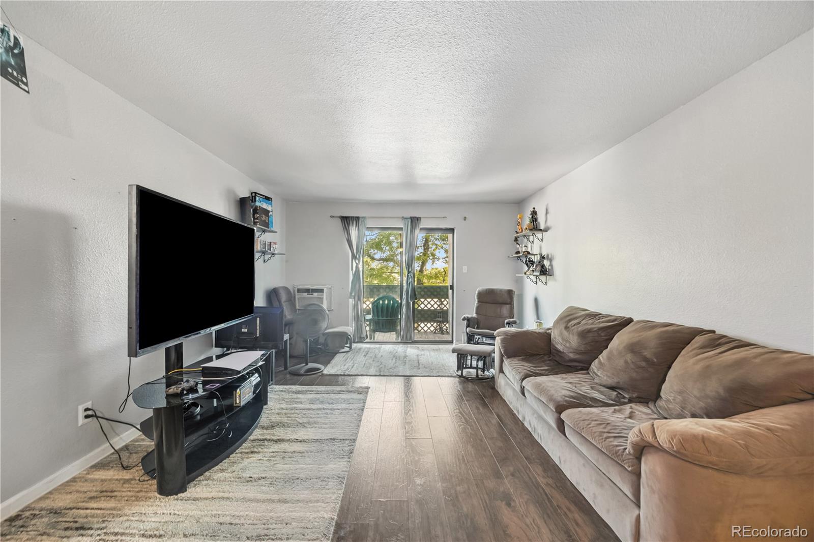 7740 West 35th Avenue, Unit 214 Wheat Ridge, CO 80033 - Photo 4 of 20 a living room with furniture and a flat screen tv