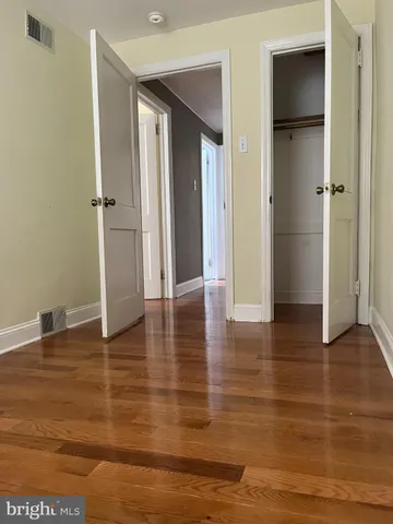 a view of empty room with wooden floor and closet