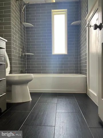 a bathroom with a toilet a sink and bathtub