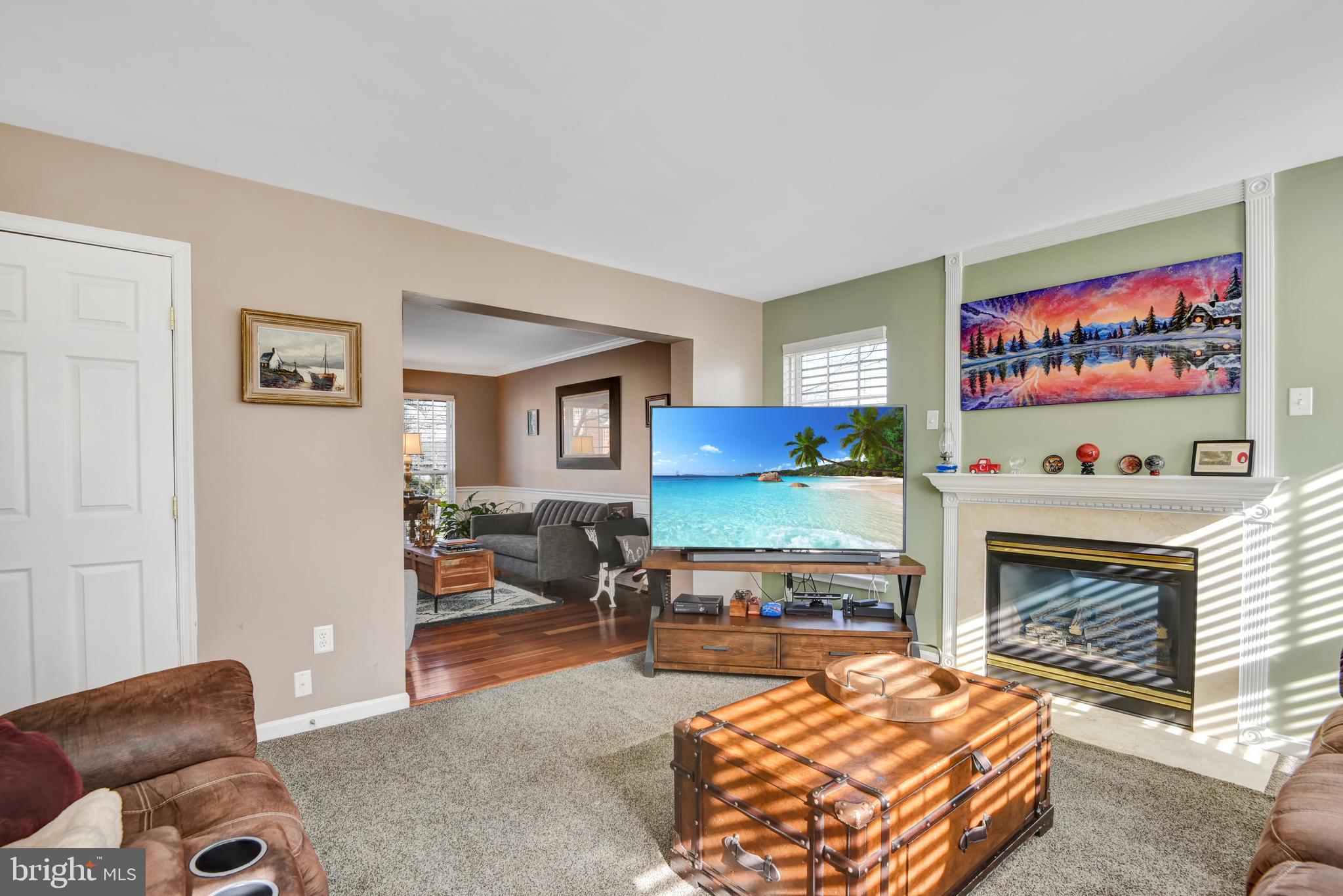 5944 Sandy Ridge Elkridge, MD 21075 - Photo 14 of 42 a living room with furniture a flat screen tv and a fireplace