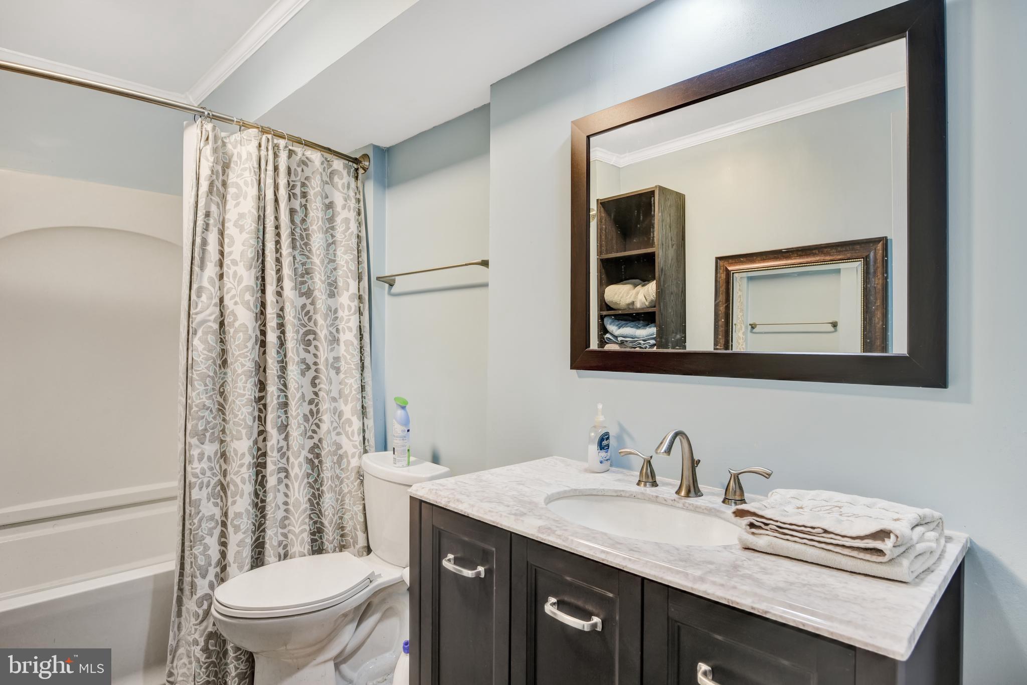 5944 Sandy Ridge Elkridge, MD 21075 - Photo 35 of 42 a bathroom with a granite countertop sink toilet a mirror and shower