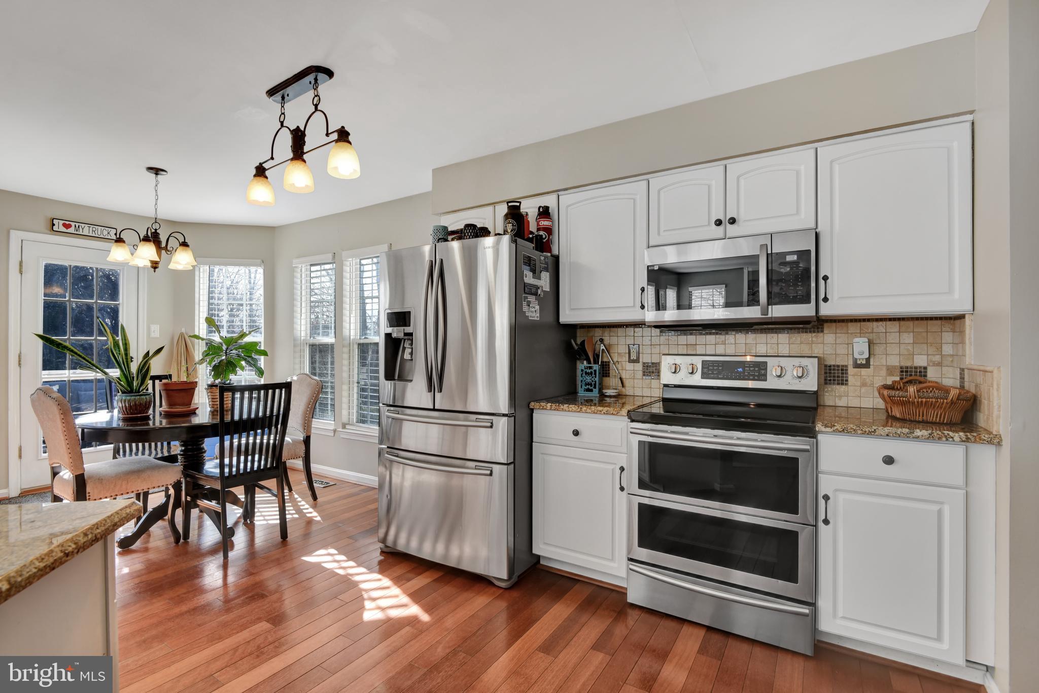 5944 Sandy Ridge Elkridge, MD 21075 - Photo 4 of 42 a kitchen with stainless steel appliances a refrigerator a stove a sink cabinets and a dining table