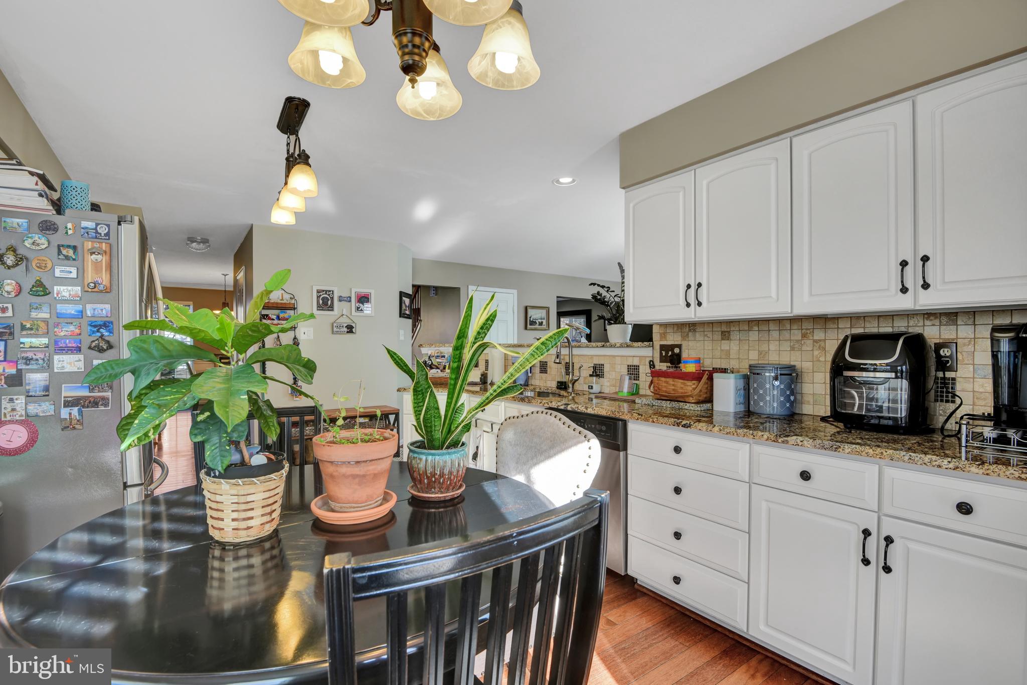 5944 Sandy Ridge Elkridge, MD 21075 - Photo 5 of 42 a kitchen with stainless steel appliances granite countertop a potted plant on the counter and wooden floor