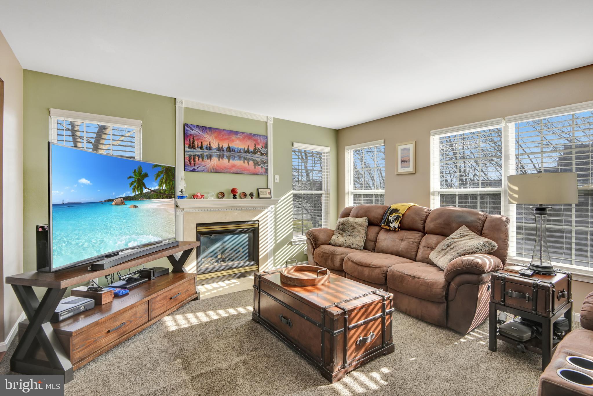 5944 Sandy Ridge Elkridge, MD 21075 - Photo 9 of 42 a living room with furniture a flat screen tv and a floor to ceiling window