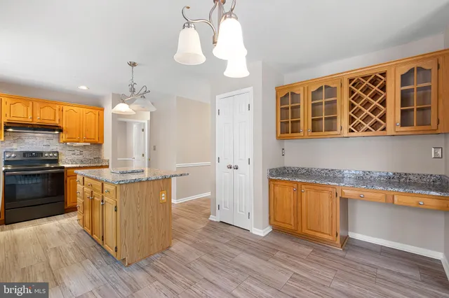 a kitchen with stainless steel appliances granite countertop wooden floors and granite counter tops