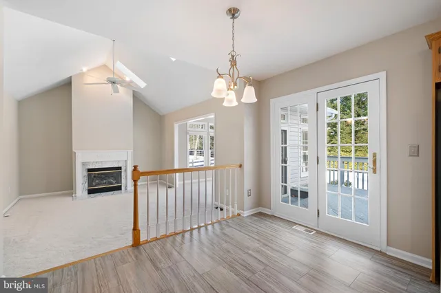 a view of a livingroom with wooden floor fireplace and a window
