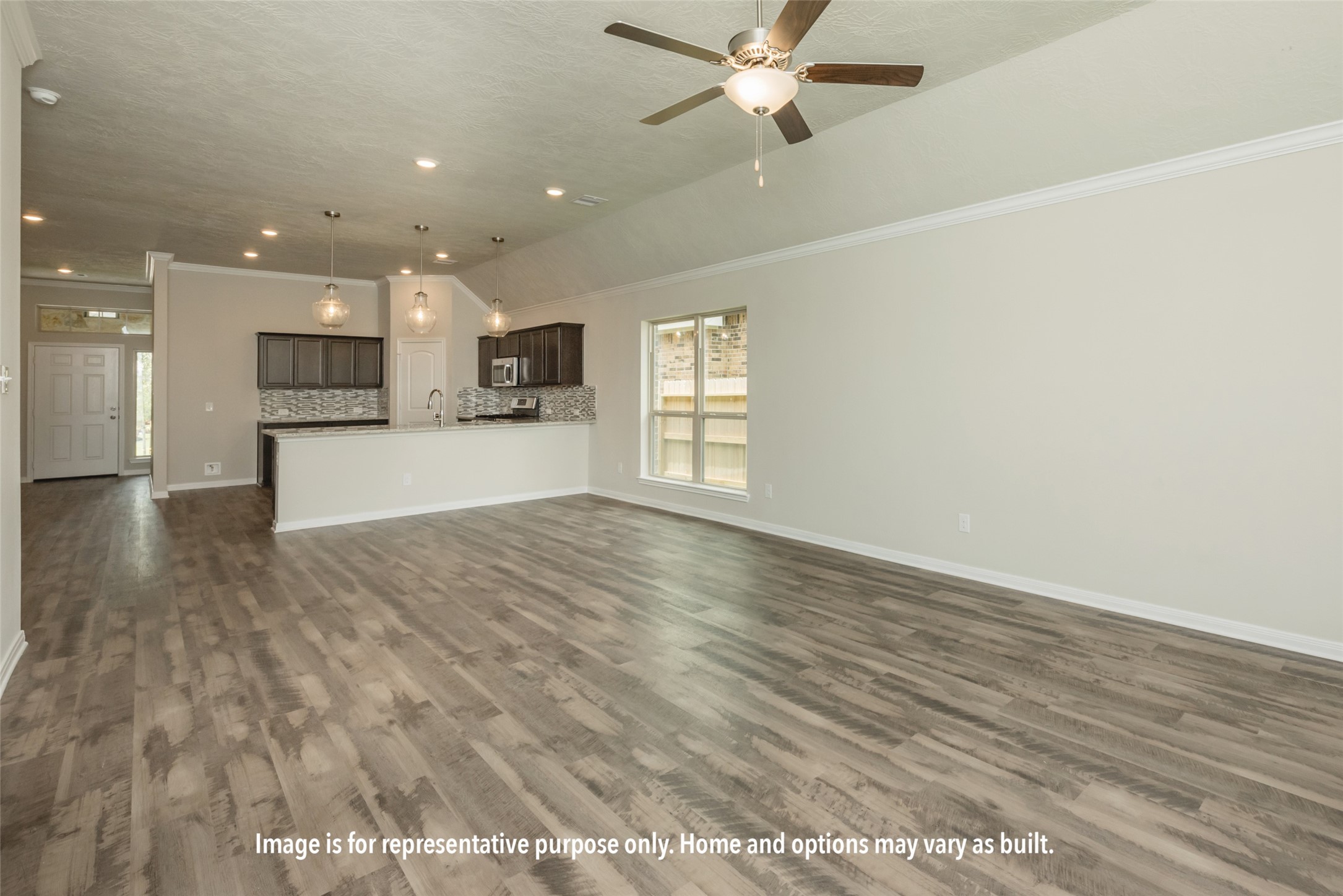 2050 Winepress Road Brenham, TX 77833 - Photo 8 of 10 an empty room with wooden floor a ceiling fan and kitchen view