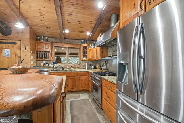 a kitchen with stainless steel appliances granite countertop a sink a stove and a refrigerator